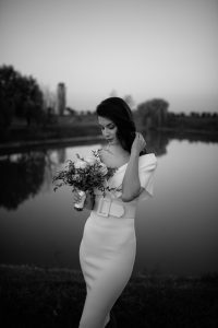 bride near lake with bouquet