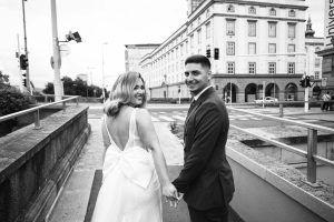 Bride and groom walking hand in hand down a street in Linz, Austria.